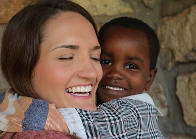 Ashley - Canadian Volunteer 2020 hugging a young student